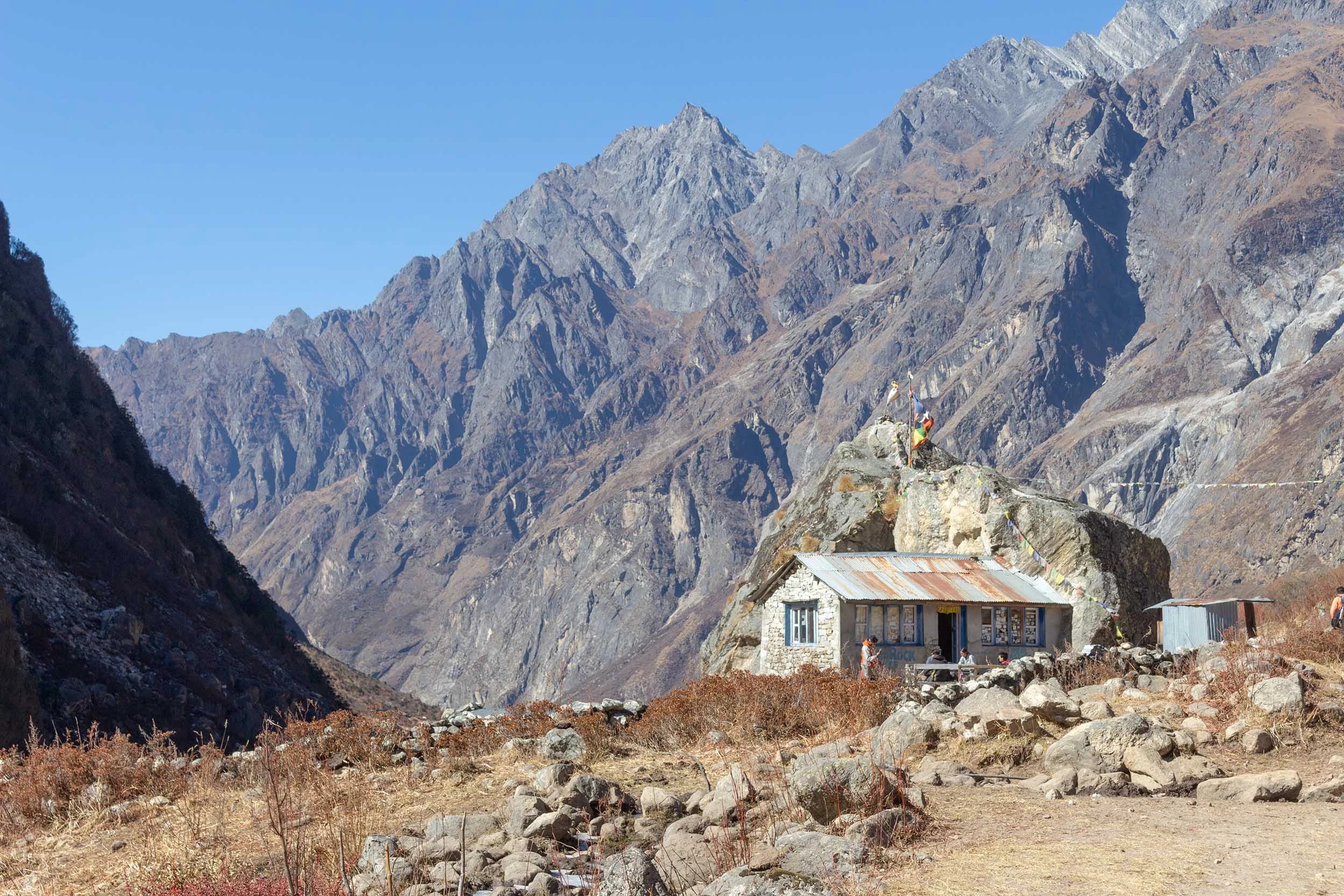 View of the Langtang Valley (Nepal) surrounded by mountains. In the front there is a small traditional house