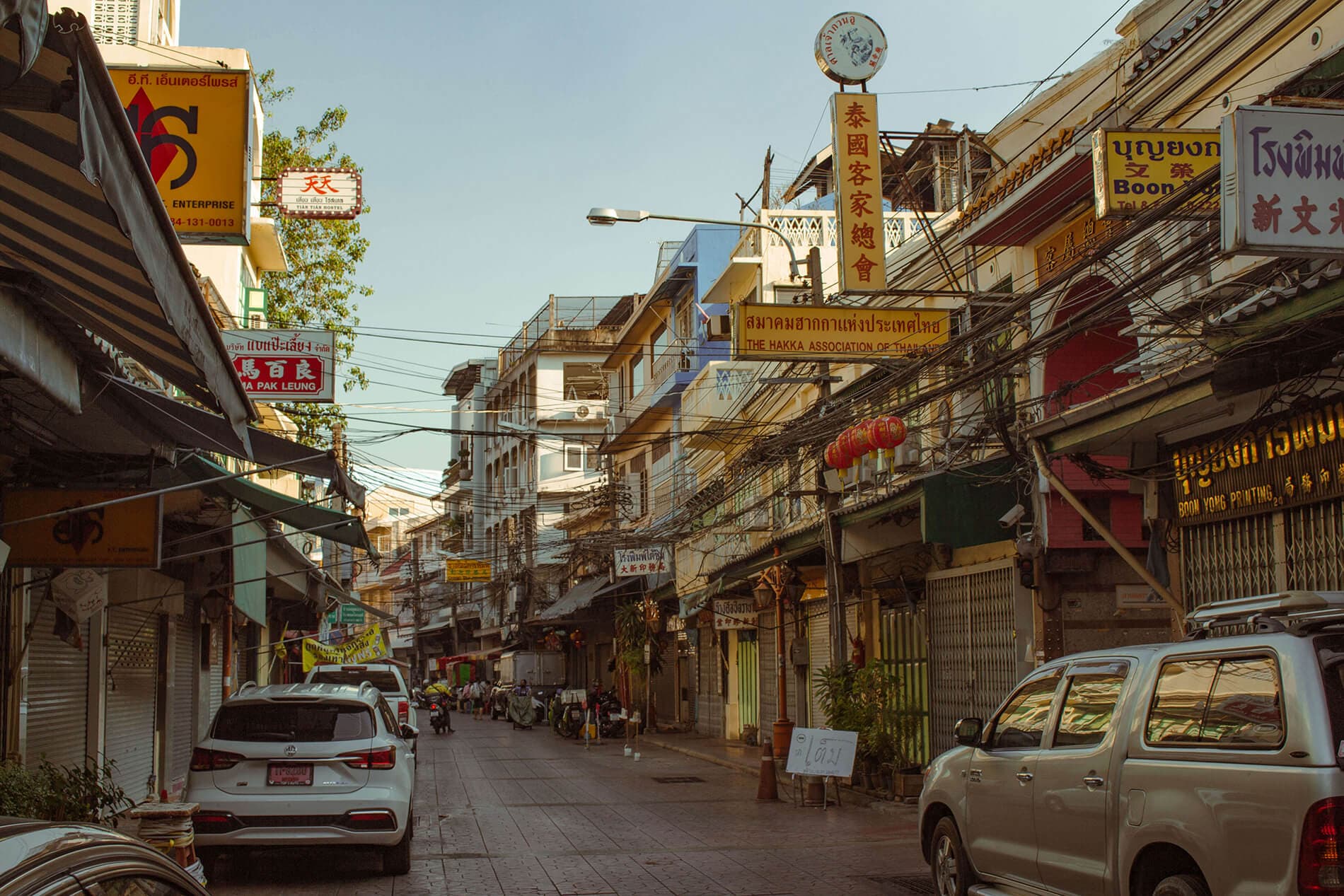 missing image Image of Chinatown, Bangkok. There are a few cars on the road and many signs from various shops. Most signs are in Chinese and they are yellow with the text in a bold red